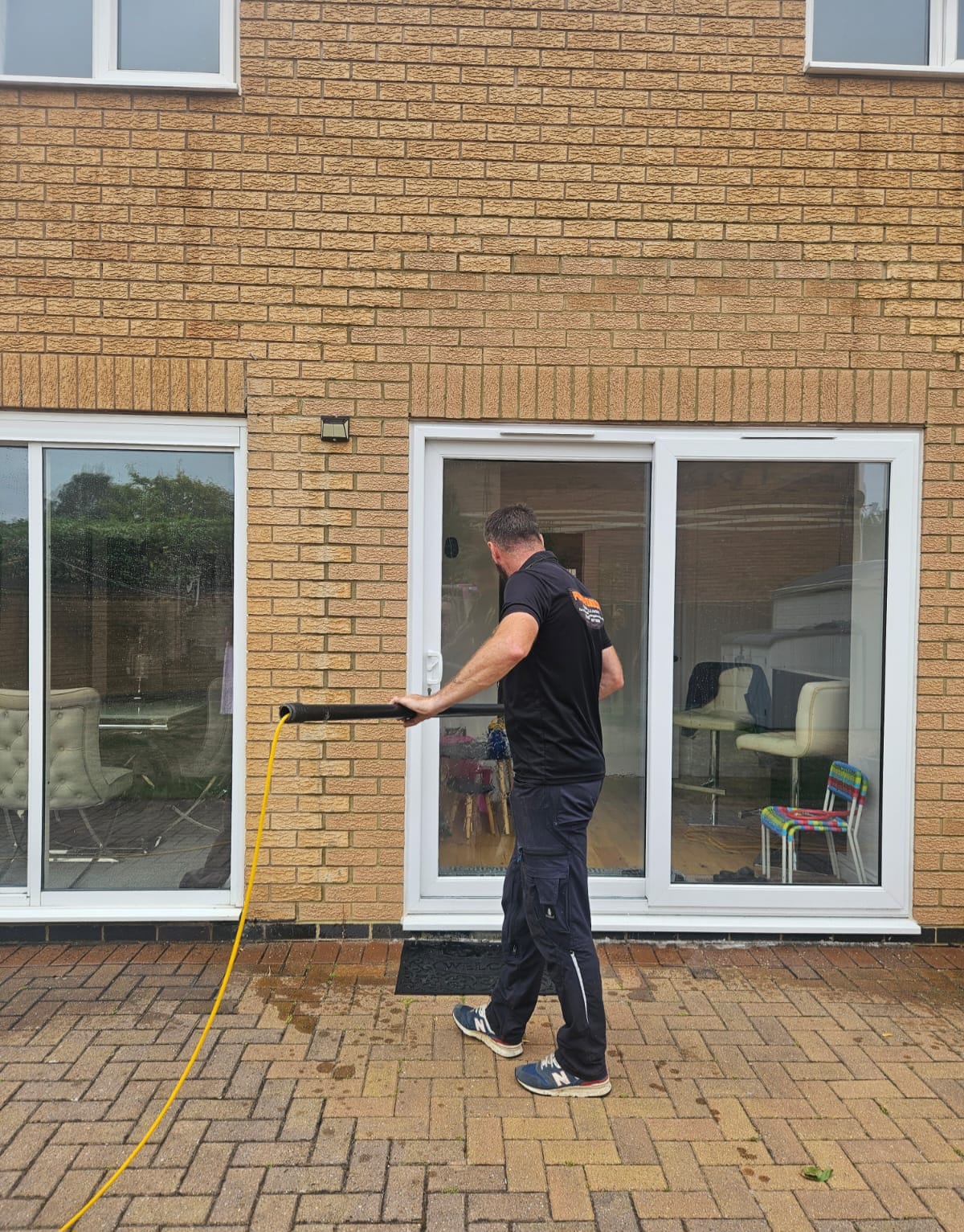 Water fed pole being set up on a block paved patio in Northampton