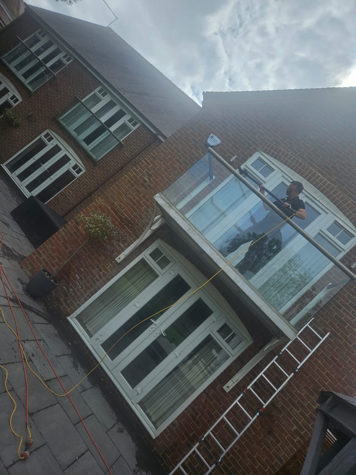 Cleaning balcony glass and French doors on a modern Northampton home